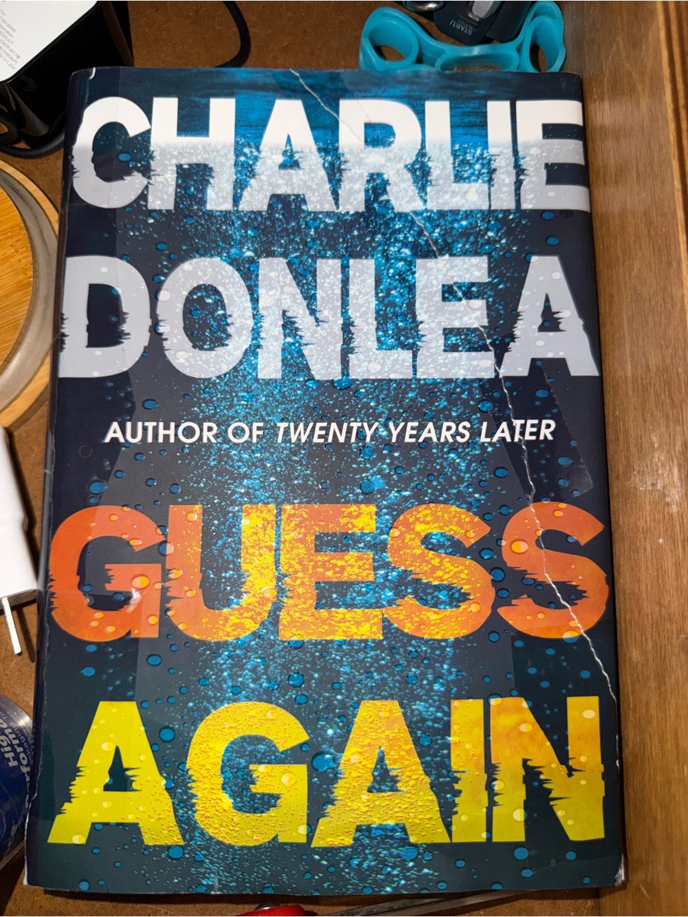 Guess Again by Charlie Donlea — Bold Blue & Yellow Hardcover